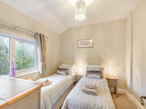 twee bedden in een kamer met een raam bij Pennypot Cottage - Uk41787 in Kettlewell