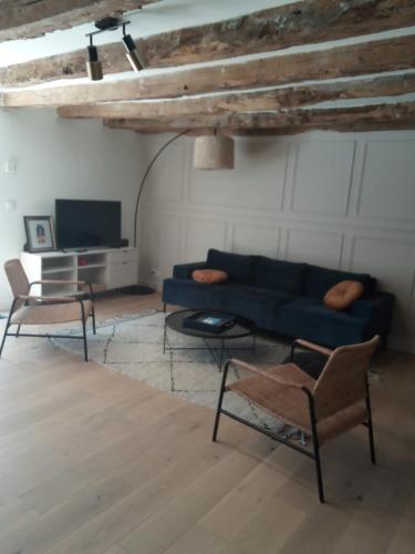 un salon avec un canapé bleu et une télévision dans l'établissement Maison chaleureuse avec piscine, à Padirac