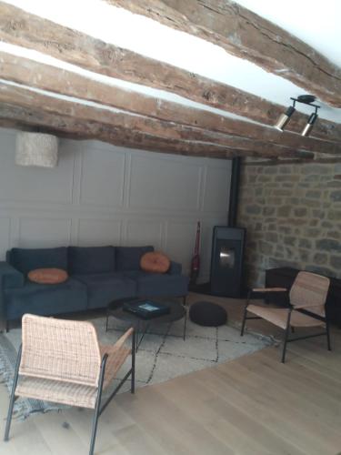 un salon avec un canapé bleu et des chaises dans l'établissement Maison chaleureuse avec piscine, à Padirac