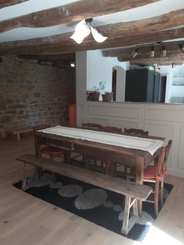 une salle à manger avec une table et un banc dans l'établissement Maison chaleureuse avec piscine, à Padirac