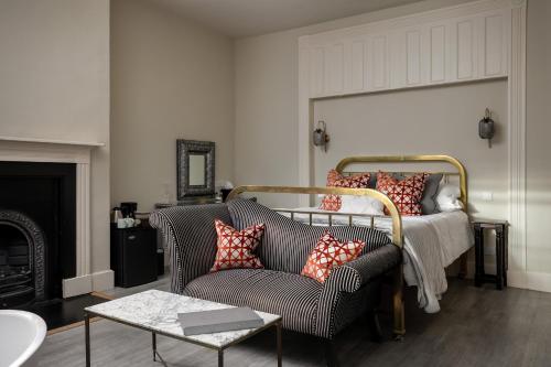 a living room with a bed and a chair at St Johns House Lichfield in Lichfield