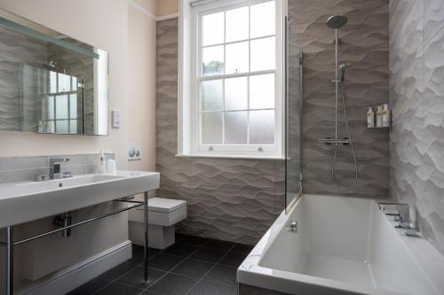 a bathroom with a shower and a sink and a tub at St Johns House Lichfield in Lichfield
