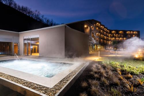 bañera de hidromasaje frente a un edificio por la noche en Minaro Hotel Tokaj MGallery - Adult Only, en Tokaj