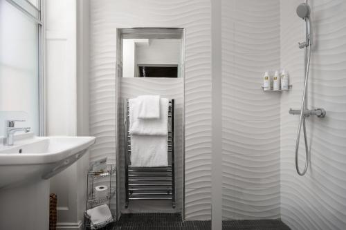a bathroom with a shower and a sink and a mirror at St Johns House Lichfield in Lichfield