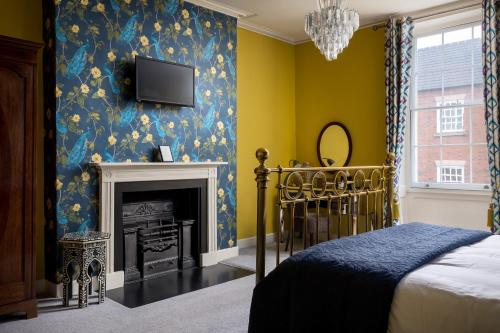 a bedroom with a bed and a tv on the wall at St Johns House Lichfield in Lichfield