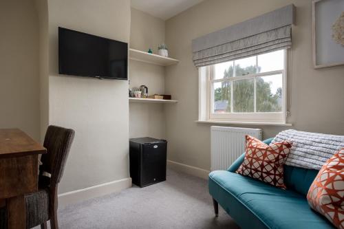 a living room with a blue couch and a window at St Johns House Lichfield in Lichfield