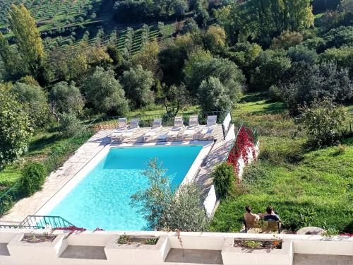 a swimming pool with two people sitting in lawn chairs next to it at Quinta da Marmela in Torres Novas