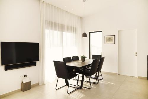 a dining room with a table and black chairs at Villa Mouria private villa just 200m from the sea in Pogoniá