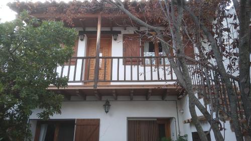 a white house with a balcony with a tree at Casa Rural El Atroje in Cardenete