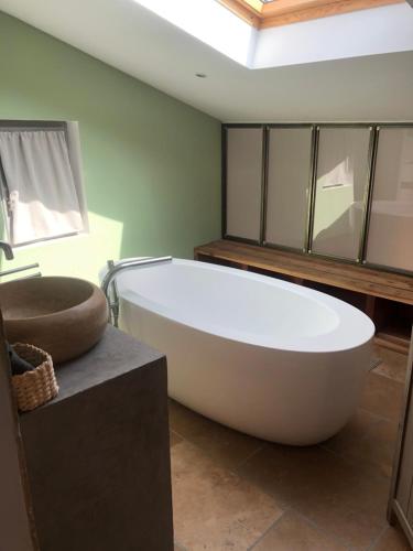 a large white bath tub in a bathroom at Ferme La Clavière, Gîte Lou Mas in Mane