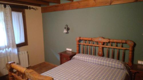 a bedroom with a wooden bed and a window at Casa Rural El Atroje in Cardenete