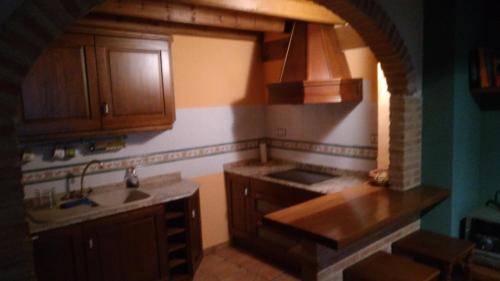 a kitchen with wooden cabinets and a sink at Casa Rural El Atroje in Cardenete