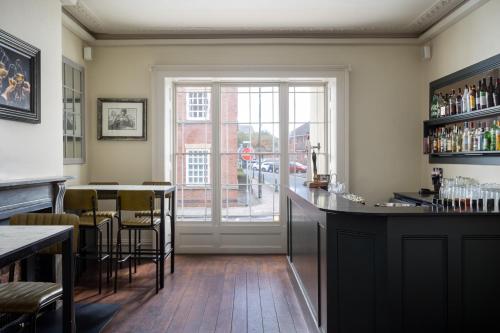 a bar in a restaurant with a view of a street at St Johns House Lichfield in Lichfield