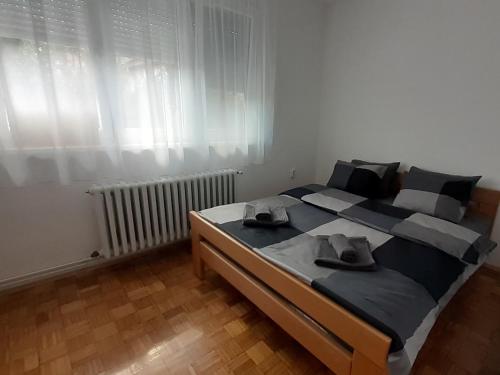 a bedroom with a large bed with two hats on it at Apartman Una in Sremski Karlovci