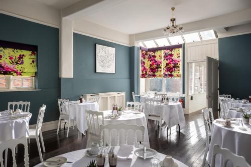 a dining room with white tables and chairs at St Johns House Lichfield in Lichfield