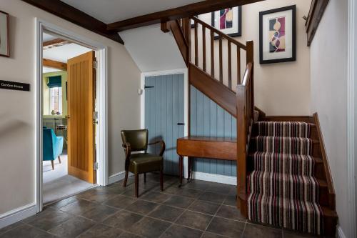 a hallway with a staircase and a chair in a house at St Johns House Lichfield in Lichfield