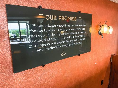 a mirror on a wall with a sign on it at PINEMARK Inn Suites Events in Saint Clair