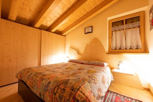 馬津的住宿－Cesa Antermoia，木制客房内的一间卧室,配有一张床