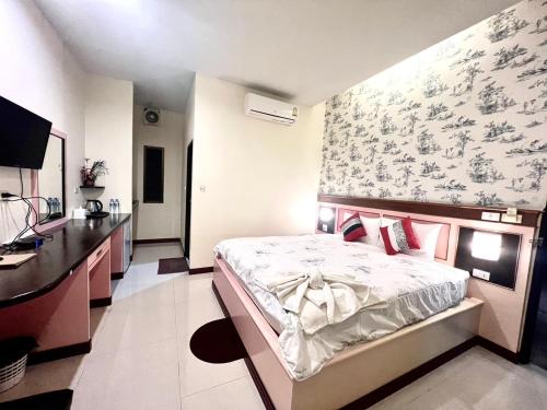 sypialnia z łóżkiem i biurkiem w obiekcie Banana Place Resort w mieście Chumphon