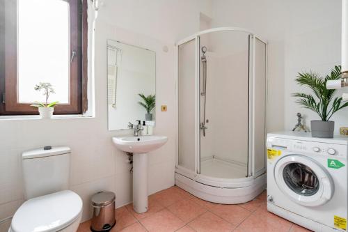 a bathroom with a shower sink and a washing machine at Chic Taksim Flat 1 min to Istiklal Ave in Istanbul