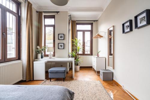 a bedroom with a bed and a desk and windows at Chic Taksim Flat 1 min to Istiklal Ave in Istanbul