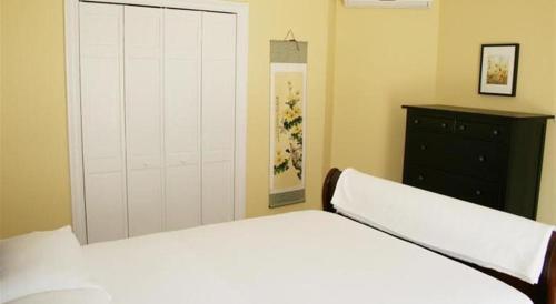 een slaapkamer met een wit bed en een dressoir bij Apartments Lozina on the Beach in Omiš