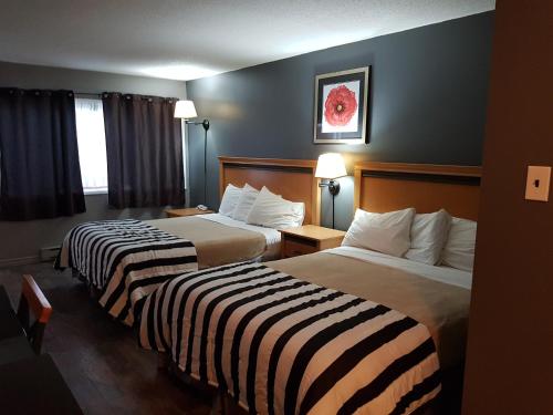 a hotel room with two beds and two lamps at Metro Inn in Victoria