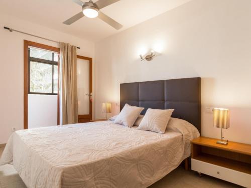 sypialnia z dużym łóżkiem i wentylatorem sufitowym w obiekcie Apartament Francesca Beach with Pool w Alcudii