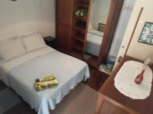 1 dormitorio con cama blanca y espejo en Aconchego da te en Río de Janeiro