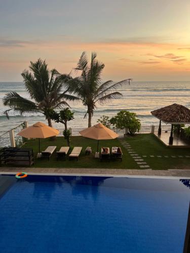a swimming pool with a view of the ocean at Surf Station in Ahangama