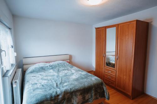 una camera da letto con un letto e un armadio in legno di CosyHouse-Kupres a Kupres