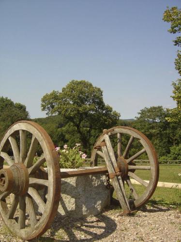 a wooden cart sitting on top of a stone bench at Moulin D’Huile in Chaumard