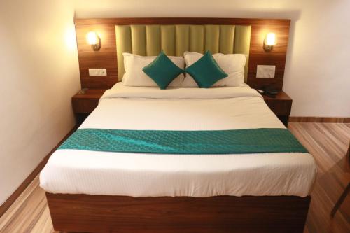 a bedroom with a large bed with green pillows at Hotel Candor Amigo Airoli Mind Space in Navi Mumbai