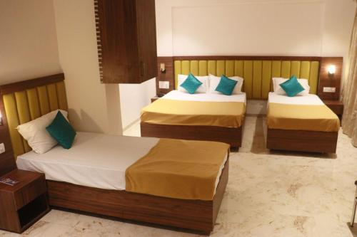 two beds in a hotel room with two bedsvisor at Hotel Candor Amigo Airoli Mind Space in Navi Mumbai
