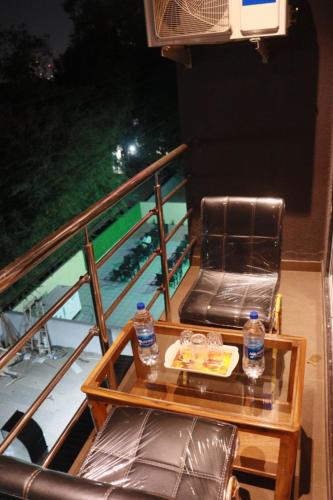 a balcony with a table and chairs and water bottles at Hotel Candor Amigo Airoli Mind Space in Navi Mumbai