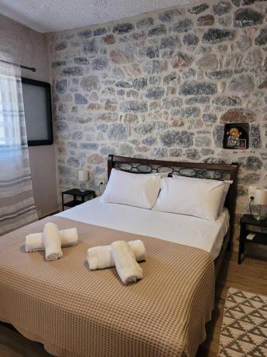 a bedroom with a large bed with two pillows on it at Filia's House (The House of Friendship) in Areopolis