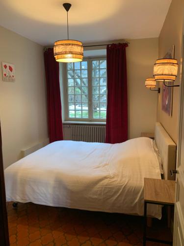 sypialnia z białym łóżkiem i oknem w obiekcie Charmant appartement jardin/parking privé 4 personnes w mieście Bourboule