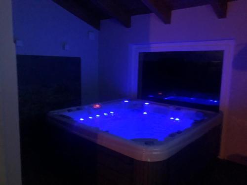 a dark room with a large tub with blue lighting at Il Vecchio Comune B&B in Cintano