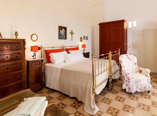 een slaapkamer met een bed, een dressoir en een stoel bij Masseria Tagliente in Martina Franca