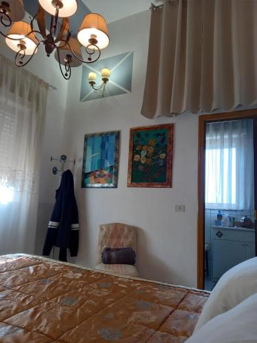 a bedroom with a bed and a chair and a window at D'ALTRITEMPI-Elegance in Cianciana. in Cianciana