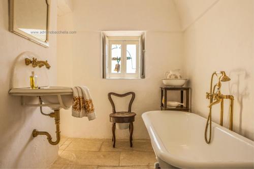 y baño con bañera, lavamanos y bañera. en Masseria Tagliente, en Martina Franca