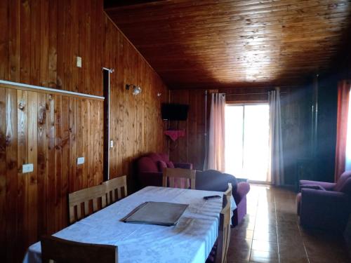 a room with a table and chairs and a window at Cabañas Marisol in Pucón