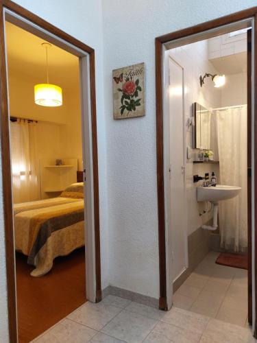 1 dormitorio con 1 cama y baño con lavabo. en Apartamento Unico Miramar en Miramar