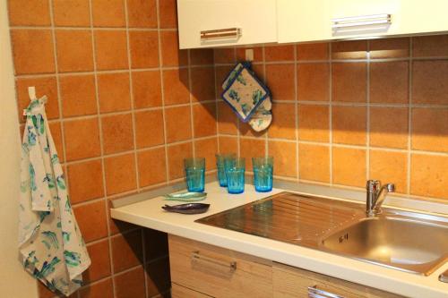 une cuisine avec évier et verres sur un comptoir dans l'établissement Kyma Flat, à Nebida