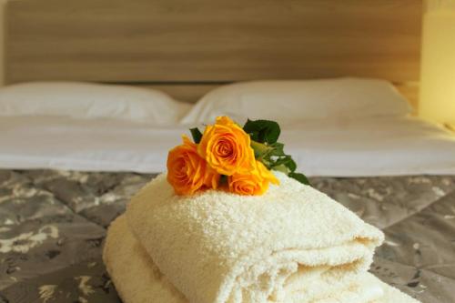 - une fleur au-dessus d'une serviette sur un lit dans l'établissement Kyma Flat, à Nebida