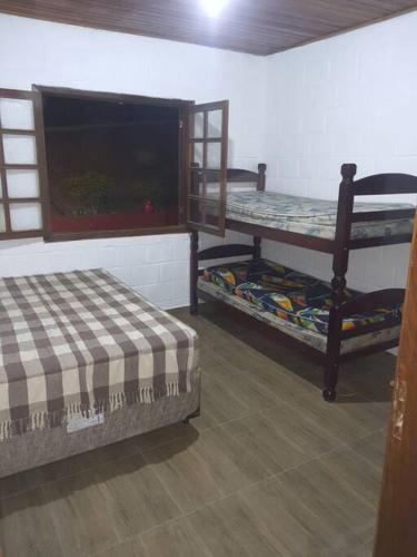 a room with two bunk beds and a tv at Chacara Vale Encantado Mairinque in Mairinque