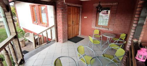 - une terrasse couverte avec des chaises, une table et une porte dans l'établissement Agroturystyka Pod Lipa, à Boreczno