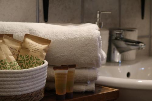 uma casa de banho com toalhas, um lavatório e uma cesta de toalhas em B&B Al Castello em Casale Litta
