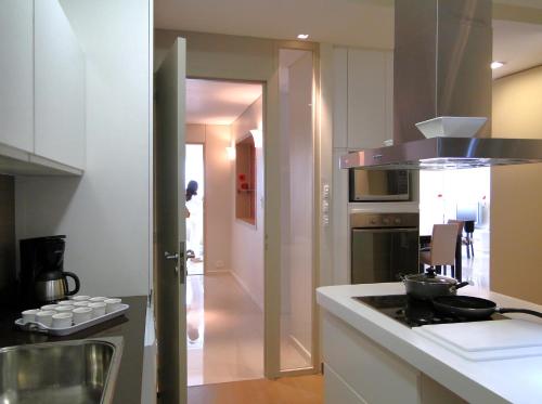 a kitchen with white cabinets and a stove top oven at Recoleta Luxury Apartment in Buenos Aires