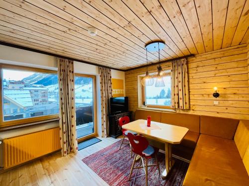 a dining room with a table and chairs and windows at Apart Samnaun in Ischgl